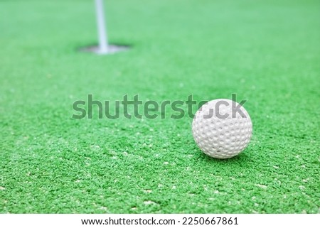 Close up picture of a golf ball at a mini golf course, selective focus.