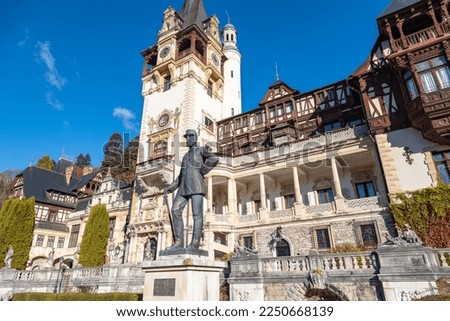 Detail of beautiful Peles Castle in Sinaia with the statue of King Carol I of Romania in front. Early autumn morning in Transylvania, Brasov region, Romania.