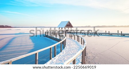 Frozen lake in winter with footbridge on sunny day. High quality photo