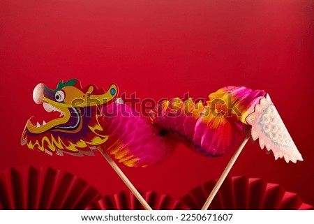 Chinese lion dance for Chinese new year with red fan in the background