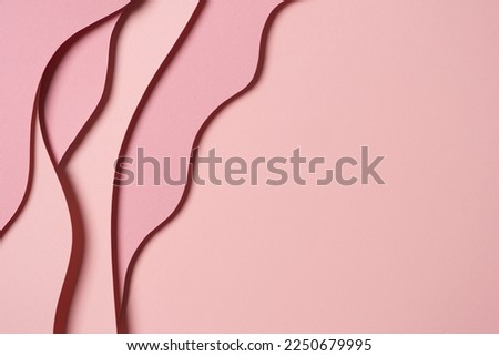 Abstract colored paper texture background. Minimal paper cut composition with layers of geometric shapes and lines in pastel pink colors. Top view, copy space