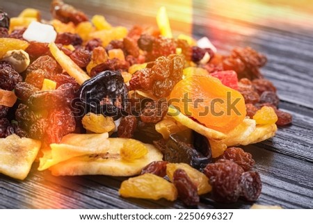 wooden background in retro style. a mixture of dried fruits lies on it. close-up. there is a tinting. soft focus