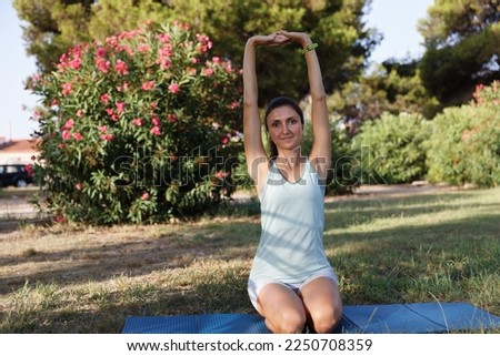Pretty woman doing yoga in morning park. Healthy lifestyle outdoor conception. Sport. Woman nature portrait doing exercises. Healthy lifestyle.