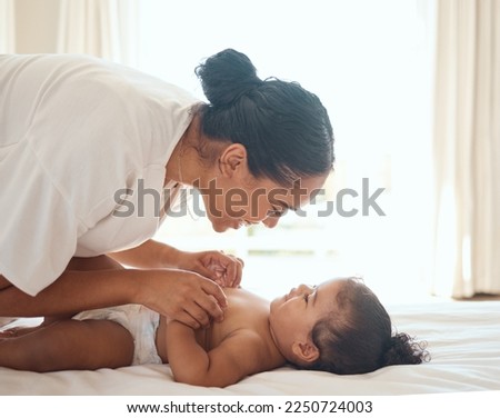 Care, playful and mother with baby on the bed in the morning with a smile for happiness in their family home. Mothers day, love and mom playing with her girl child in a bedroom or nursery in a house
