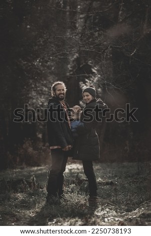 New born fall family photo shoot in forest with happy family in warm jackets