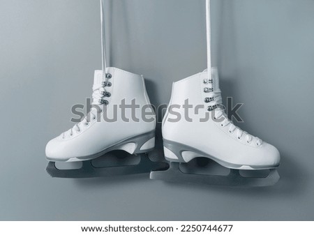 Pair of white figure ice skates shoes on blank gray background