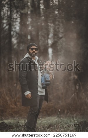 Rad dad with new born baby, part of family photo shoot in the fall by the woods.
