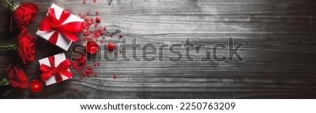 Valentines background. Flower and present on wooden table.