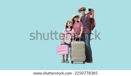 Family Travel Concept, Full body Happy asian family vacation, Father, mother and little daughter carrying suitcases and Take a picture together with smart phone. isolated on pastel plain light blue
