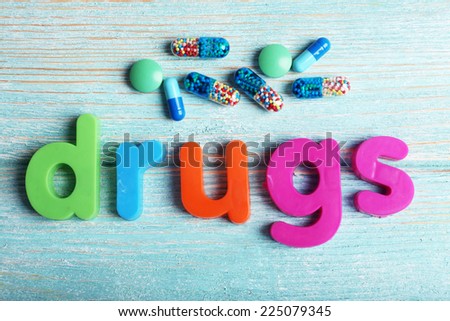 Drugs word formed with colorful letters on wooden background
