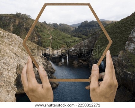 person holding frame with open nature landscape concept.