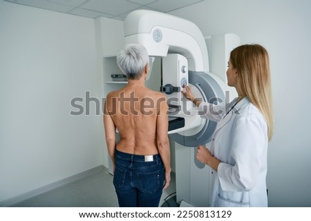 Mammography test. X-ray breast examination of mature female patient with radiology technician in mammography radiology room at medical clinic Royalty-Free Stock Photo #2250813129