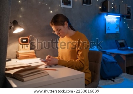 Female college student studying in dormitory at late night. Copy space