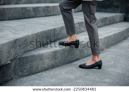Stepping going up stairs in city, Closeup legs of businesswoman hurry up walking on stairway, rush hour to work in office a hurry in morning, foot of business woman wear black shoes step up success Royalty-Free Stock Photo #2250834481