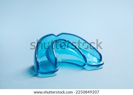 Dental mouth guard on light blue background, closeup. Bite correction Royalty-Free Stock Photo #2250849207
