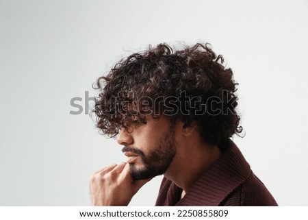 Thoughtful young man, with curly hair. Mind set and mental health. Mock-up. Royalty-Free Stock Photo #2250855809