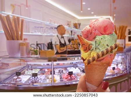 Italian ice - cream cone held in hand on the background of  shop  in Rome , Italy .It is one of the best ice cream place in town popular among tourists Royalty-Free Stock Photo #2250857043