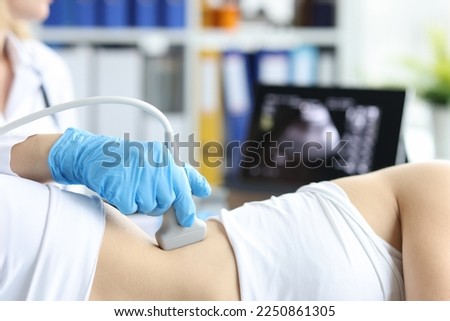Doctor examines patient with prolapse of left kidney and spleen using ultrasound probe Royalty-Free Stock Photo #2250861305