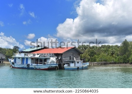 A fishing boat that is leaning on a floating house