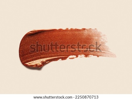 Brown claret burgundy satin finish lipstick smudge isolated on beige background 