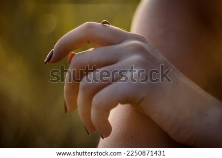 Close up woman holding ladybug on finger concept photo. Playing with insect outdoor. Front view photography with blurred background. High quality picture for wallpaper, travel blog, magazine, article