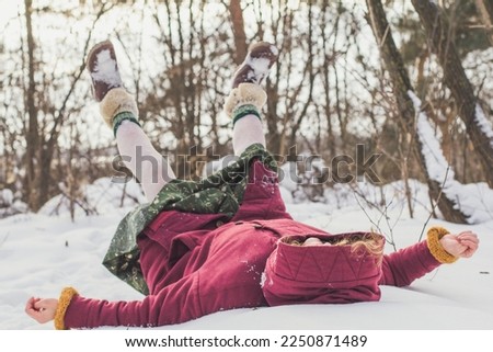 Enjoying time and lying on snow in forest scenic photography. Picture of happy woman with snowy woodland on background. High quality wallpaper. Photo concept for ads, travel blog, magazine, article