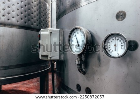 Wine fermentation tanks. Manometers on steel cylinder storages.