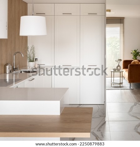 Modern kitchen with white cupboards, countertops and lamp and mirror wall with reflection of living room Royalty-Free Stock Photo #2250879883