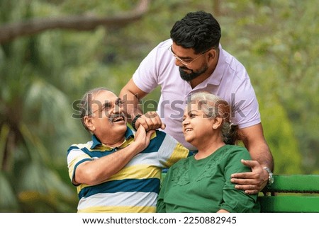 Young Indian man with his parents at park Royalty-Free Stock Photo #2250882945
