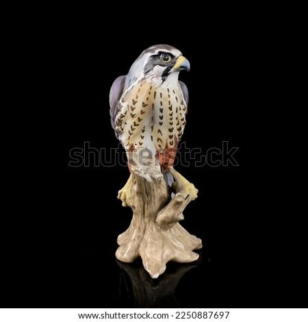 antique figurine of a hawk on a black isolated background. eagle toy. vintage porcelain bird figurine
