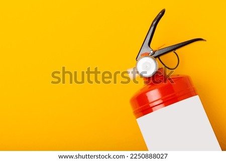 Fire extinguisher on a yellow background. Fire protection, home fire extinguisher. home security concept. Place for text. Copy space.