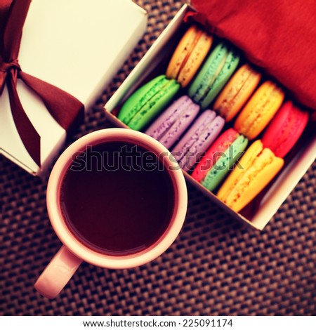 Christmas coffee break with gift box and macaroons with a retro vintage instagram filter.