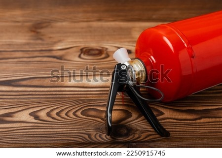 Fire extinguisher on brown wood background. Fire protection, home fire extinguisher. home security concept. Place for text. Copy space.