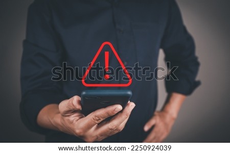 Businessman or User, programmer, developer using smart phone with triangle caution warning sign for notification error and maintenance warning and safety concept. Royalty-Free Stock Photo #2250924039