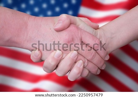 Handshake on United States flags, hands of democrats and republicans shaking щт usa united states of america flag, concept, closeup Royalty-Free Stock Photo #2250957479