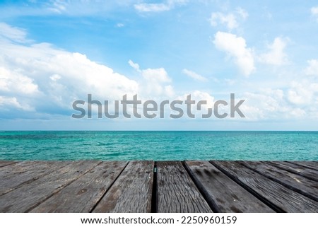 Abstract background. Wood table on top of blurred abstract beach background. Summer vibe background can be use to show or display products for commercial uses. Blurred image of sea and blue summer sky