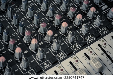 Closeup and detail of audio mixing console with faders and knobs. used for audio production