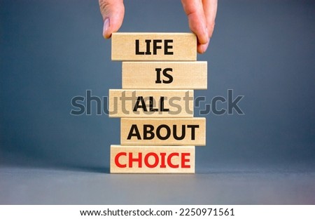 Choice and life symbol. Concept words Life is all about choice on wooden blocks. Beautiful grey table grey background. Businessman hand. Business choice and life concept. Copy space.