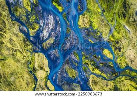 Top view of abstract blue glacier rivers pattern flowing through volcanic moss field in Icelandic highlands on summer Royalty-Free Stock Photo #2250983673