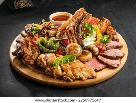 grilled meat assortment with pepper, grilled potato, tomato and greens Royalty-Free Stock Photo #2250991647