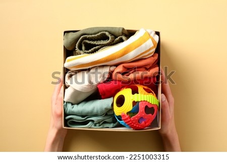 Woman donating clothes for children in need. Perfect for promoting charitable campaigns, raising awareness about importance of clothing donation for children. Royalty-Free Stock Photo #2251003315