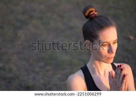 A pretty young White woman practicing yoga outdoors