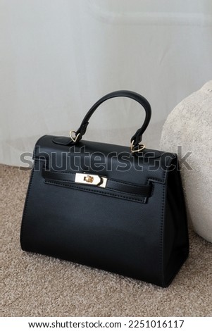 Black designer bag with gold accents Royalty-Free Stock Photo #2251016117