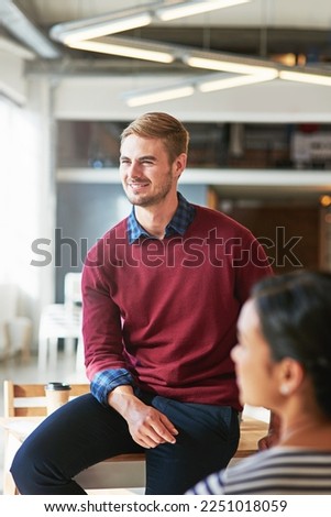 Man, business people and office with focus, learning and development of career for teamwork success. Modern office, woman and coworker sitting on table for marketing, team building or conversation