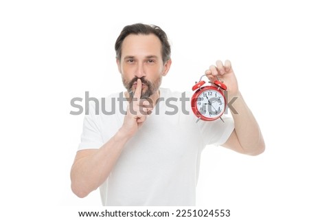 photo of man with alarm clock show hush gesture, keep calm. hush man with alarm clock