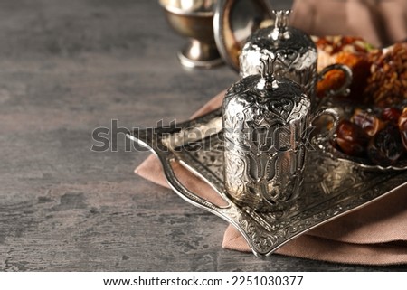 Tea, Turkish delight and date fruits served in vintage tea set on grey textured table, space for text
