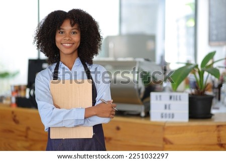 Young African woman small business start-up owner working in a cafe. Employee working in a coffee shop.