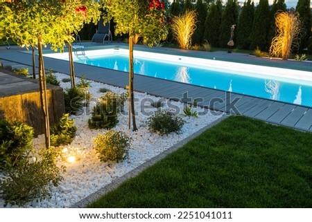 Scenic Residential Outdoor Swimming Pool Illuminated by LED Lighting. Poolside Surrounding Theme. Royalty-Free Stock Photo #2251041011