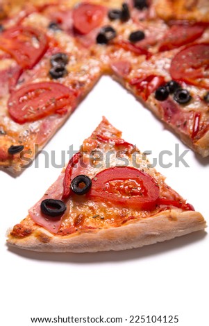 Tasty pizza with ham, tomatoes and olives with a slice removed, selective focus on slice  