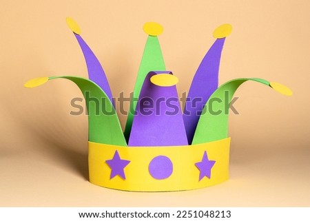 Mardi gras carnival jester hat on head made of paper . Step by step photo instructions DIY from 9 steps on neutral background. Step 9 of 9. Royalty-Free Stock Photo #2251048213